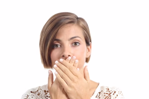 A woman covering her mouth with her hands.