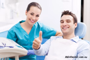 A man and woman giving thumbs up in a dentist's chair.